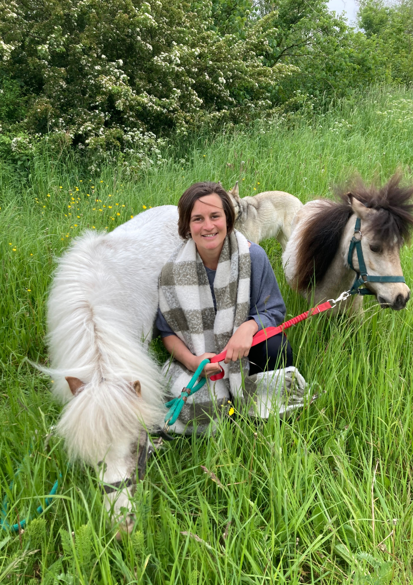 Joke zit naast haar paarden die kinderen met ADHD helpen meer zelfvertrouwen te ervaren